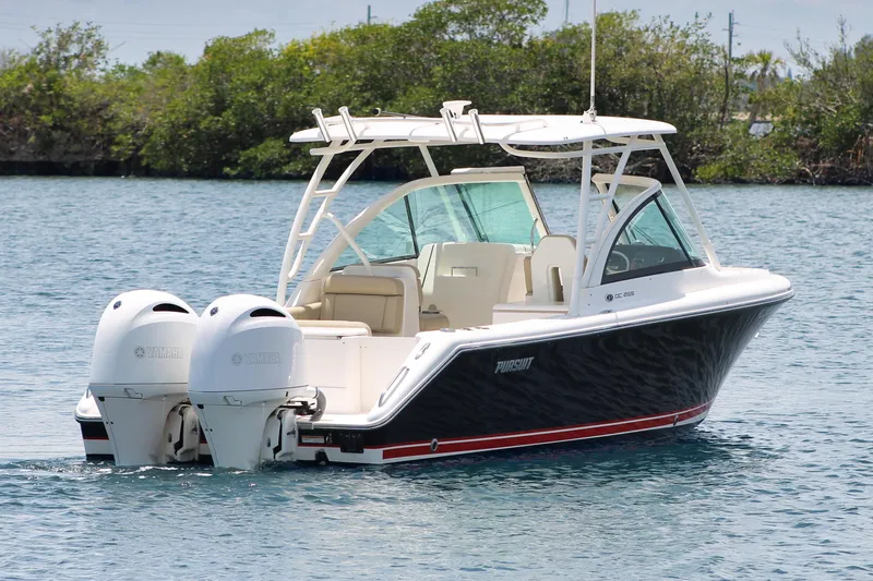 Slide: The Image of 2018 Pursuit DC 265 Dual Console boat on water, featuring twin Yamaha engines. - 2
