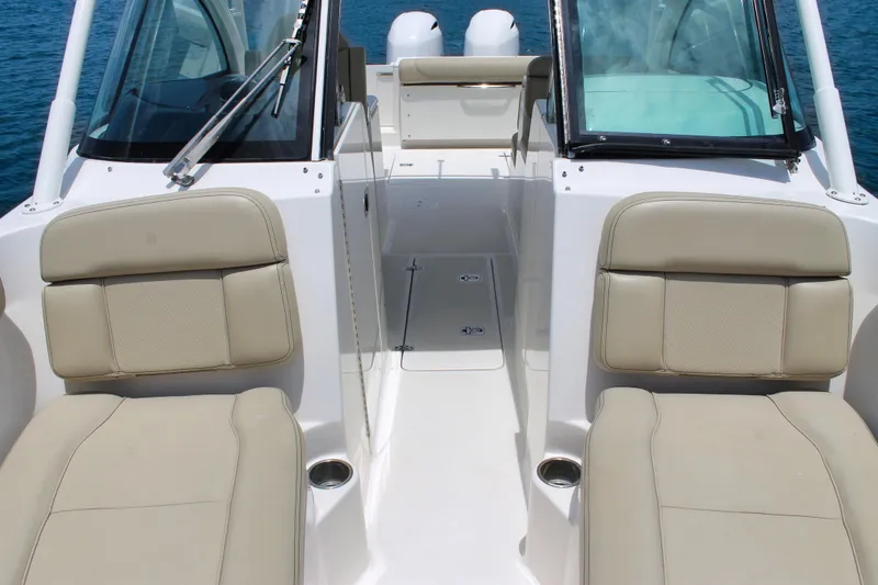 Slide: The Image of 2018 Pursuit DC 265 Dual Console boat interior with beige seating and open deck. - 20