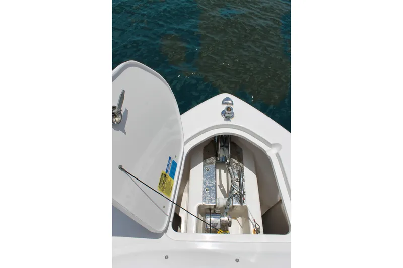Slide: The Image of 2018 Pursuit DC 265 Dual Console anchor compartment open on calm water. - 23