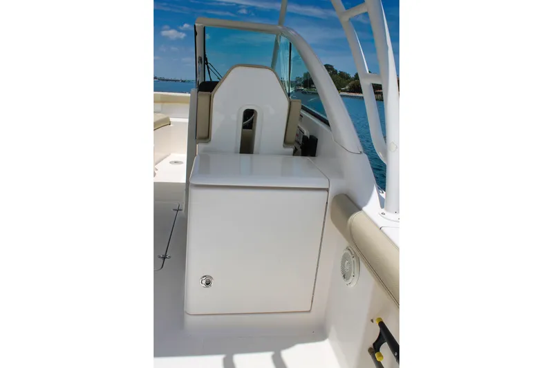 Slide: The Image of 2018 Pursuit DC 265 Dual Console boat interior with seating and storage, on a sunny day. - 25