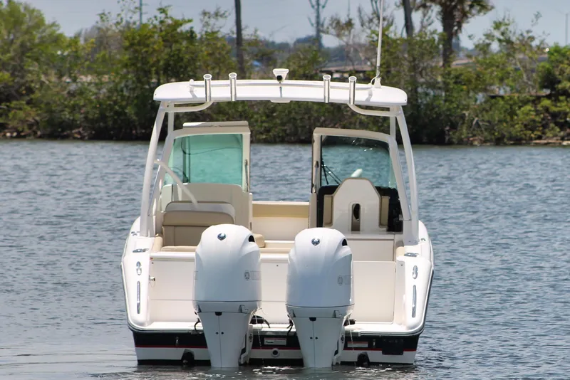 Slide: The Image of 2018 Pursuit DC 265 Dual Console boat on water, rear view with twin engines. - 3