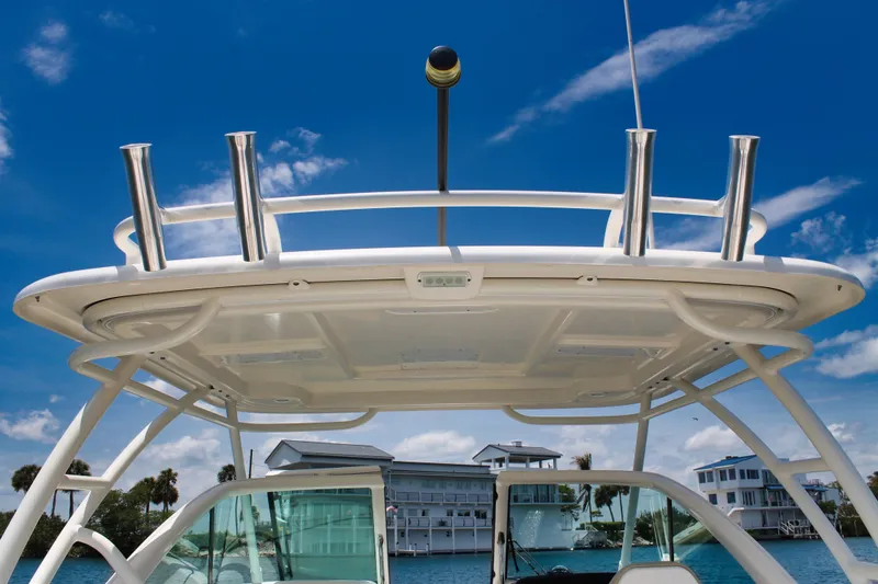 Slide: The Image of 2018 Pursuit DC 265 Dual Console boat with rod holders, under a clear blue sky. - 31