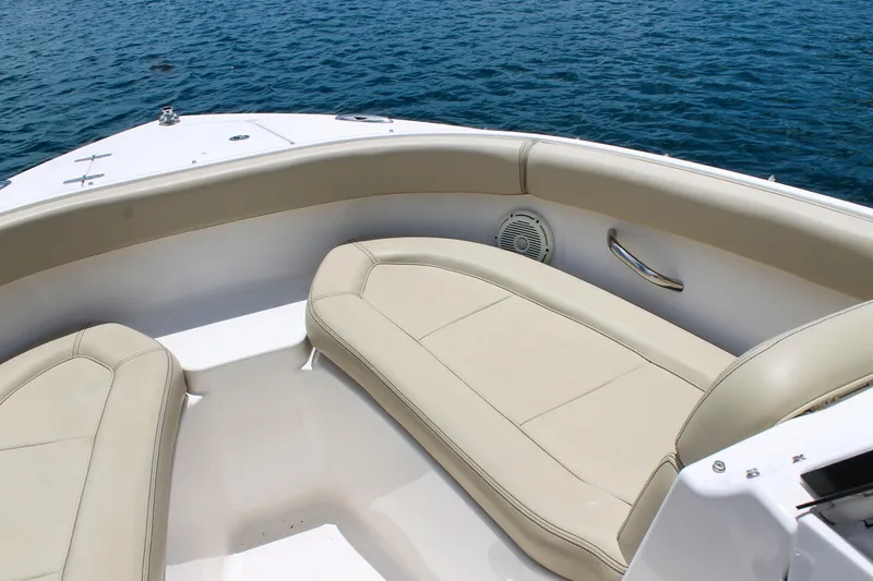 Slide: The Image of 2018 Pursuit DC 265 Dual Console boat interior with beige seating and ocean view. - 35