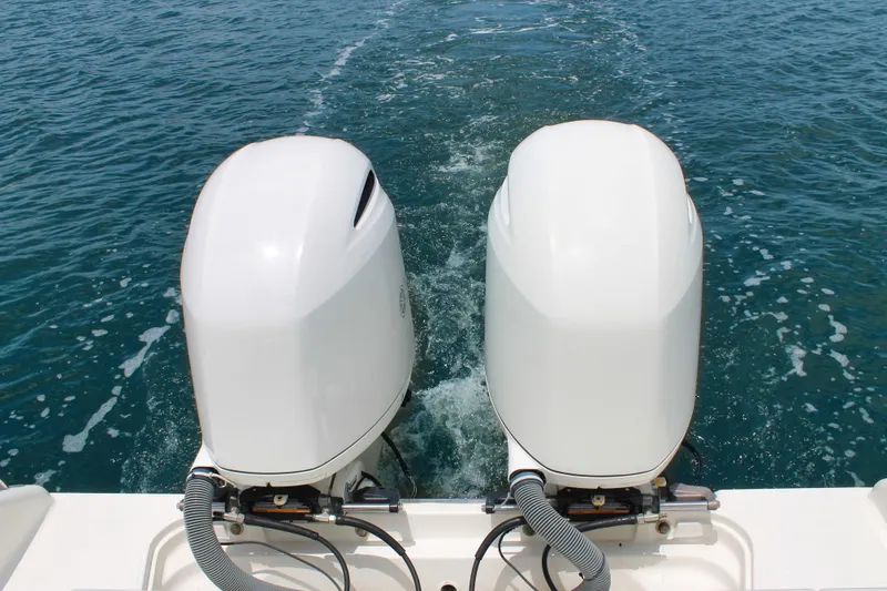 Slide: The Image of 2018 Pursuit DC 265 Dual Console boat with twin outboard motors on open water. - 36