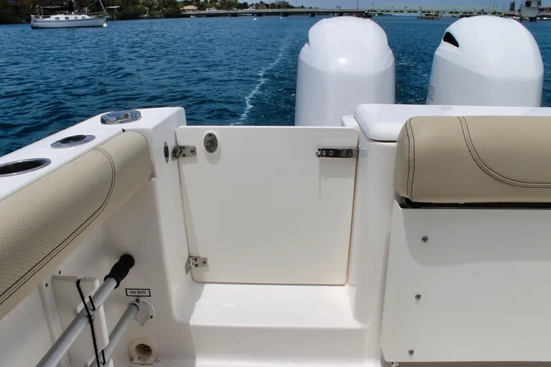 Slide: The Image of 2018 Pursuit DC 265 Dual Console boat interior with twin engines on blue water. - 37