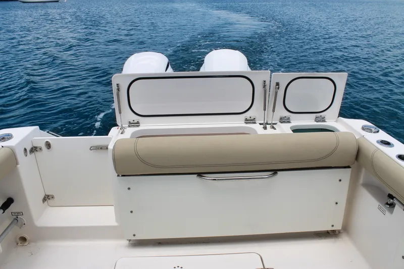 Slide: The Image of 2018 Pursuit DC 265 Dual Console boat on water, featuring rear seating and storage. - 40