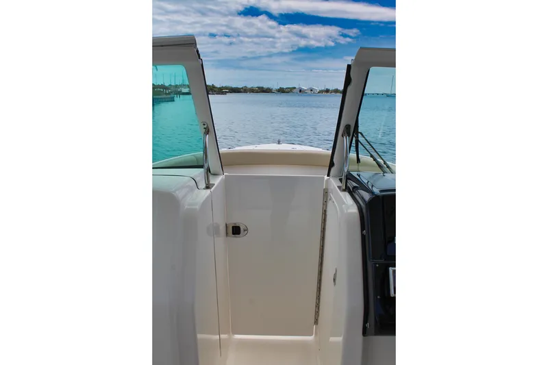 Slide: The Image of 2018 Pursuit DC 265 Dual Console boat interior with open doors, overlooking serene water. - 41