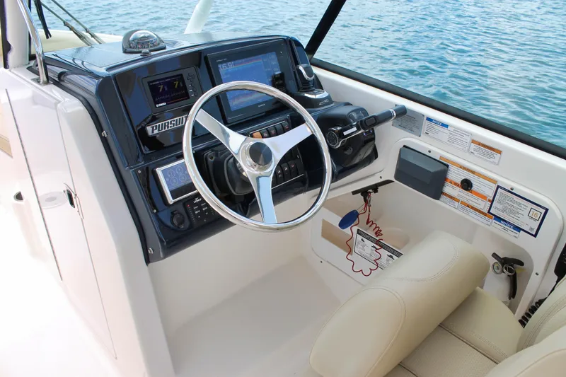 Slide: The Image of 2018 Pursuit DC 265 Dual Console boat cockpit with steering wheel and control panel. - 45
