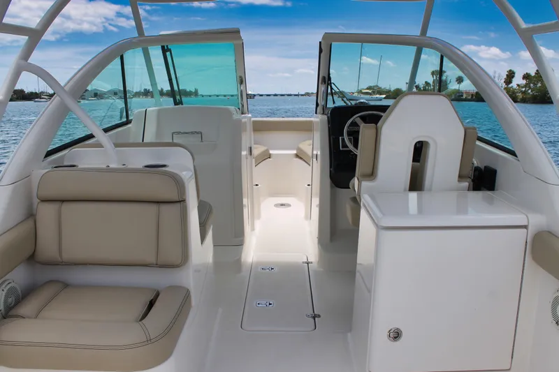 Slide: The Image of 2018 Pursuit DC 265 Dual Console boat interior with seating and helm, on calm water. - 46