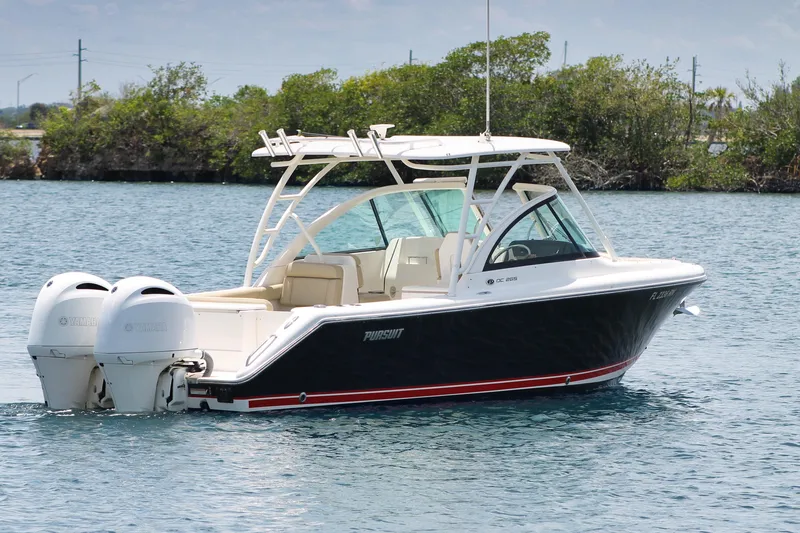 Slide: The Image of 2018 Pursuit DC 265 Dual Console boat on water, featuring twin Yamaha engines. - 6