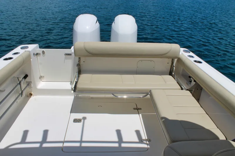 Slide: The Image of 2018 Pursuit DC 265 Dual Console boat with beige seating, on calm blue water. - 8
