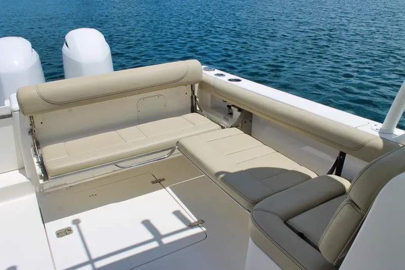 Slide: The Image of 2018 Pursuit DC 265 Dual Console boat with beige seating, on calm blue water. - 9