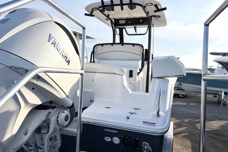 Slide: The Image of 2026 Sea Hunt Ultra 255 SE boat with Yamaha engine, docked under clear sky. - 13