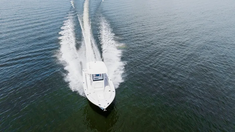 Slide: The Image of 2026 Sea Hunt Ultra 255 SE boat cruising on open water, aerial view. - 23