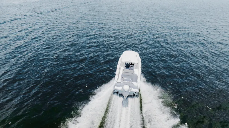Slide: The Image of 2026 Sea Hunt Ultra 255 SE boat cruising on open water, aerial view. - 26