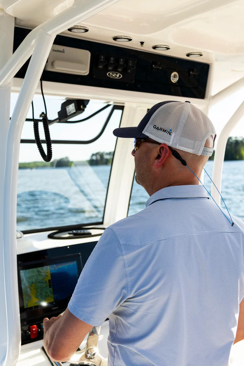 Slide: The Image of Man steering 2026 Sea Hunt Ultra 255 SE boat on open water. - 28