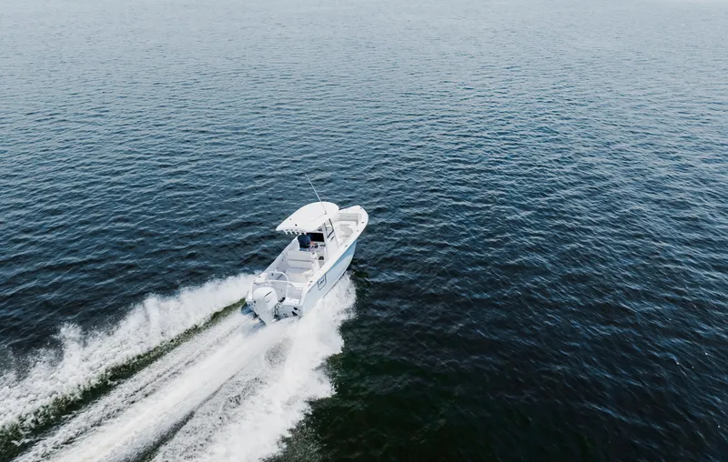 Slide: The Image of 2026 Sea Hunt Ultra 255 SE boat cruising on open water, aerial view. - 31