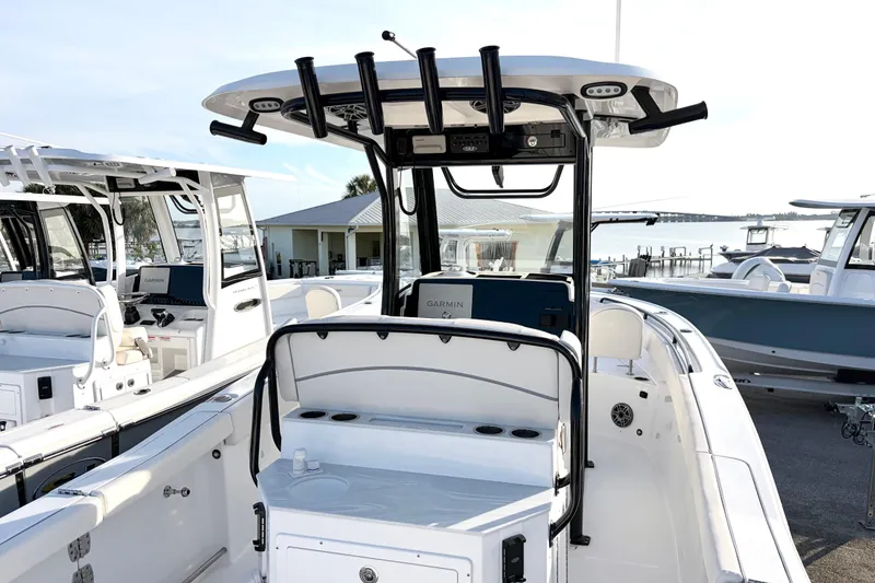 Slide: The Image of 2026 Sea Hunt Ultra 255 SE boat with modern console and seating at a marina. - 9