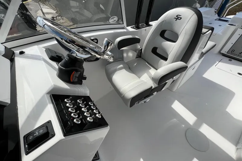Slide: The Image of 2026 Sea Pro 240 Dual Console boat interior with steering wheel and captain's chair. - 11