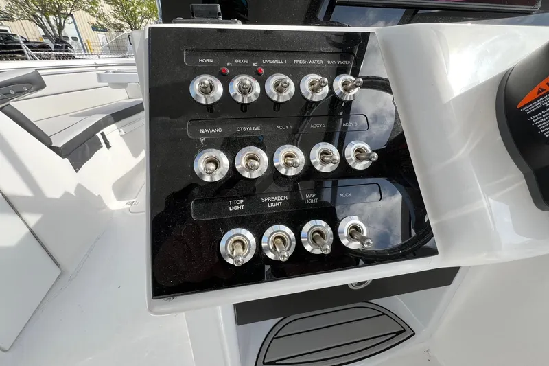 Slide: The Image of Control panel of 2026 Sea Pro 240 Dual Console boat with multiple switches. - 13