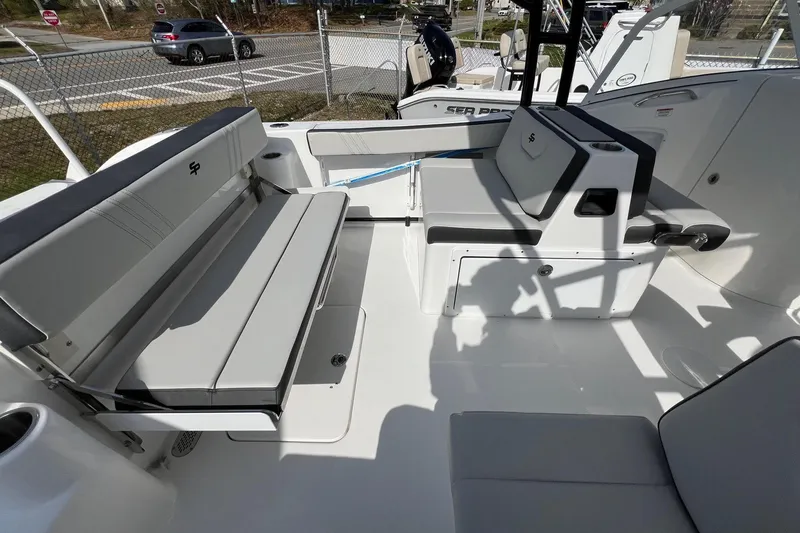 Slide: The Image of 2026 Sea Pro 240 Dual Console boat interior with gray seating and storage compartments. - 19