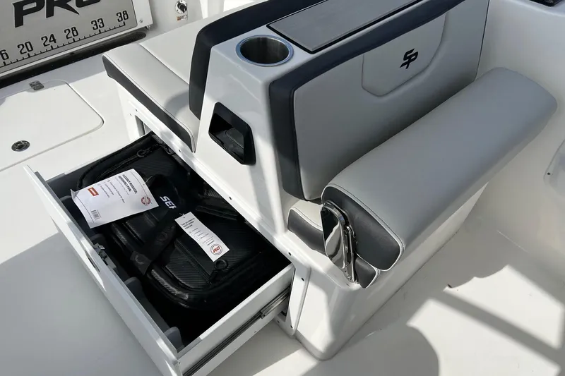Slide: The Image of 2026 Sea Pro 240 Dual Console boat seat with storage drawer open, showing contents. - 21