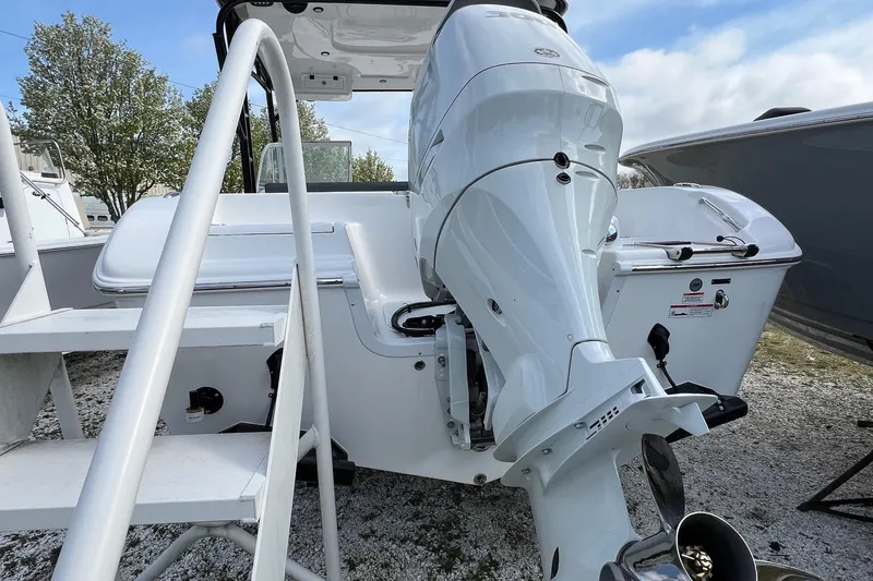 Slide: The Image of 2026 Sea Pro 240 Dual Console boat with powerful outboard motor, docked outdoors. - 7