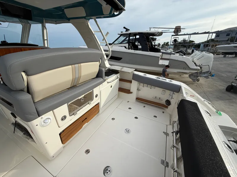 Slide: The Image of The image shows the cockpit of a 2027 Boston Whaler 350 Realm with gray and beige seating. - 32