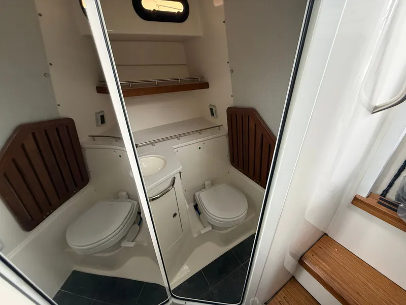 Slide: The Image of The image shows a modern boat bathroom with two toilets and a sink. - 21