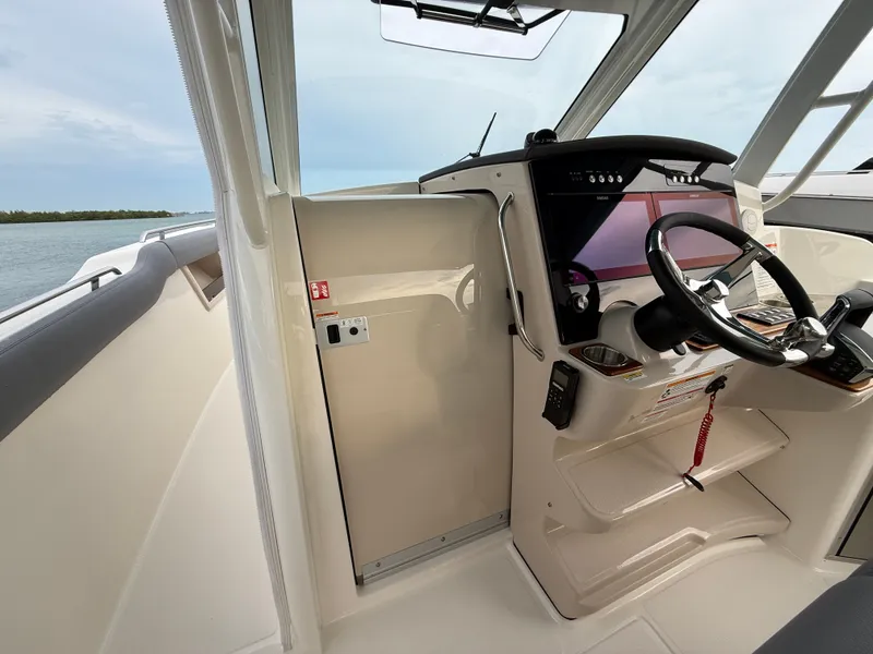 Slide: The Image of The cockpit of a 2027 Boston Whaler 350 Realm with modern steering and electronics. - 17