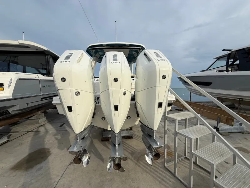 Slide: The Image of Three powerful outboard engines on a Boston Whaler 350 Realm, parked at a dock. - 5