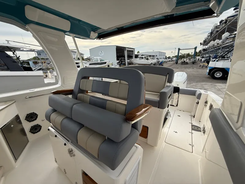 Slide: The Image of The image shows the cockpit of a 2027 Boston Whaler 350 Realm with gray and beige seating. - 25