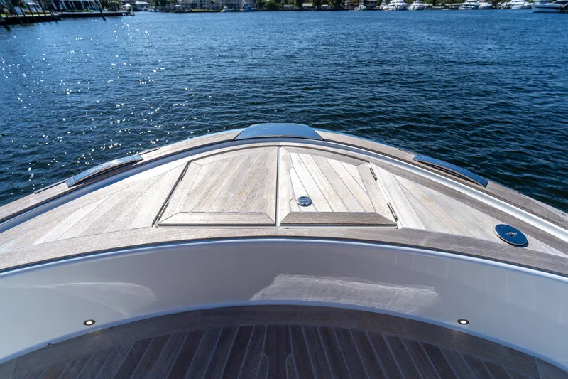 Slide: The Image of 2025 Solaris Power 44 Open yacht bow with sleek wooden deck on calm water. - 34