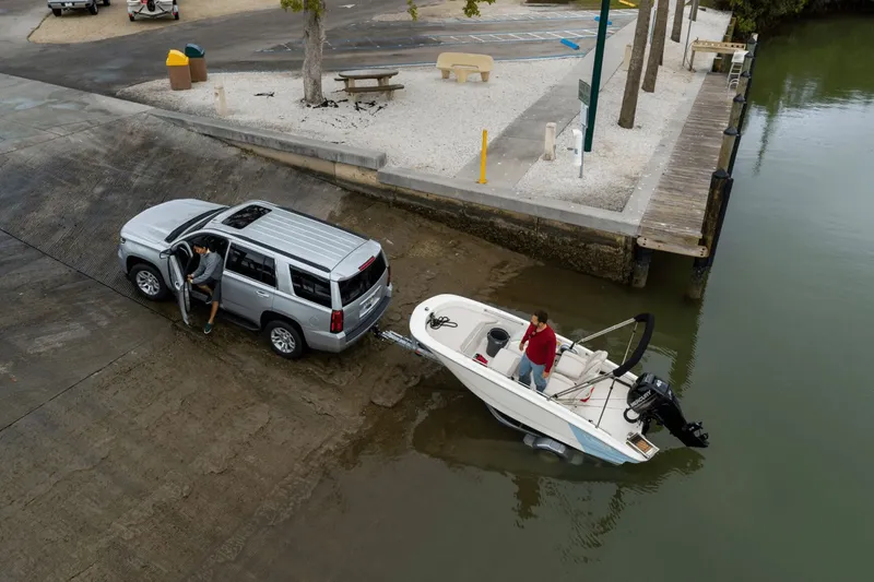 Slide: The Image of A Boston Whaler 130 Super Sport being launched into the water by a vehicle. - 11