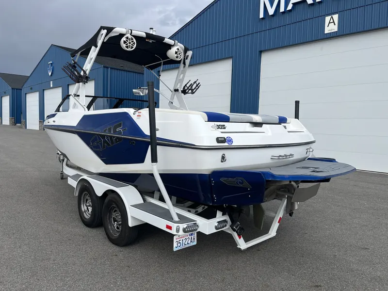Slide: The Image of 2019 Axis T22 boat on trailer in front of blue warehouse. - 10