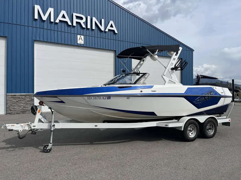 Slide: The Image of 2019 Axis T22 boat in front of a blue marina. - 2