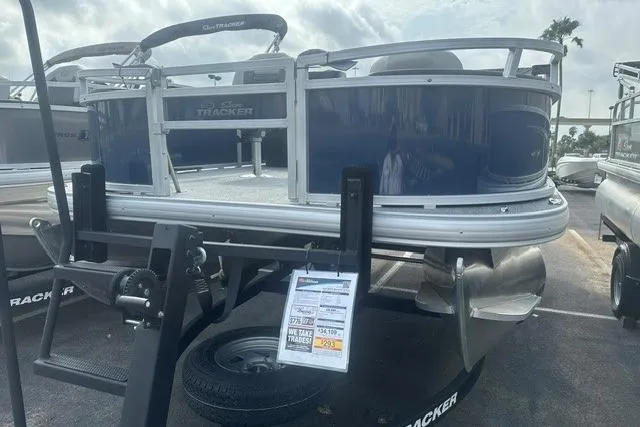 Slide: The Image of 2026 Sun Tracker Bass Buggy 18 DLX pontoon boat on trailer, displayed outdoors. - 1