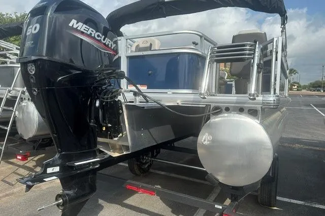 Slide: The Image of 2026 Sun Tracker Bass Buggy 18 DLX pontoon boat with Mercury engine in parking lot. - 3