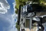 Slide: The Image of 2026 Sun Tracker Bass Buggy 18 DLX pontoon boat under a clear blue sky. - 86