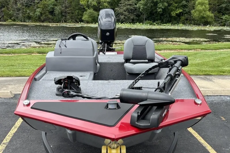 Slide: The Image of 2026 Tracker Bass Tracker Classic XL boat, red exterior, parked near a scenic lake. - 2