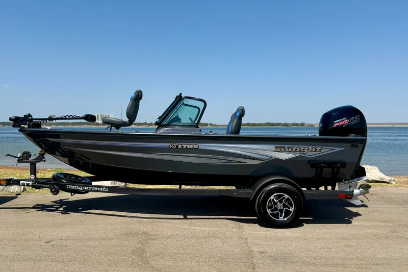 Slide: The Image of 2026 Ranger VS1782SC Reata boat on trailer by a lake. - 0