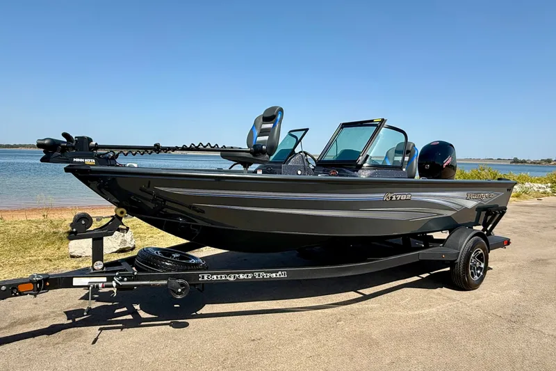 Slide: The Image of 2026 Ranger VS1782SC Reata boat on trailer by a lake, sunny day. - 1