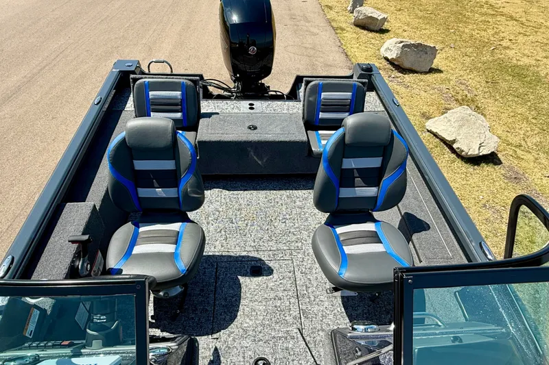 Slide: The Image of 2026 Ranger VS1782SC Reata boat interior with four seats and motor, parked on grass. - 12