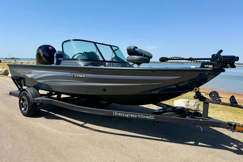 Slide: The Image of 2026 Ranger VS1782SC Reata boat on trailer by a lake, sunny day. - 2