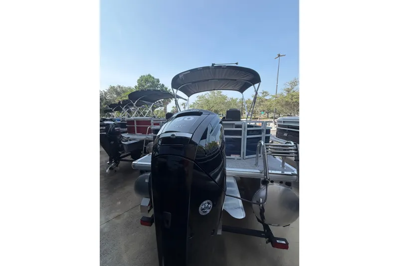 Slide: The Image of 2026 Sun Tracker SportFish 20 DLX pontoon boat with outboard motor, docked outdoors. - 9