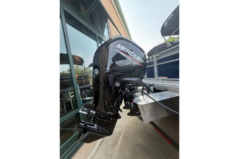 Slide: The Image of 2026 Sun Tracker SportFish 20 DLX with Mercury outboard motor, parked outdoors. - 8