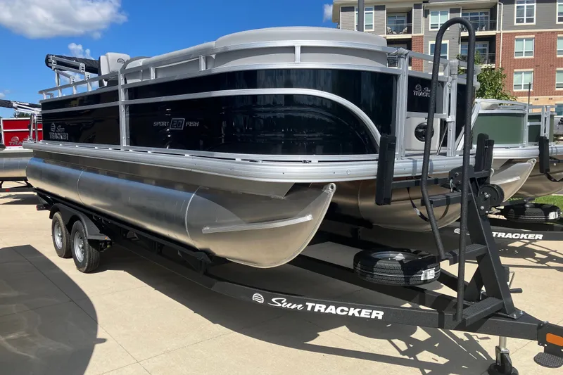 The Image of 2026 Sun Tracker SportFish 20 DLX pontoon boat on trailer, parked outdoors. - 0