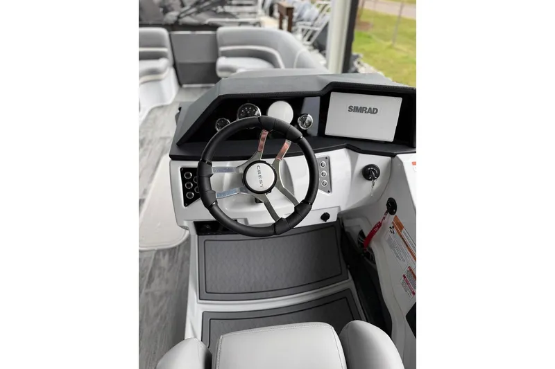 Slide: The Image of 2026 Crest Caribbean 250 SLRC boat helm with steering wheel and Simrad display. - 13