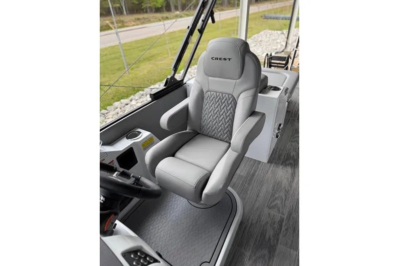 Slide: The Image of Captain's chair in 2026 Crest Caribbean 250 SLRC boat, featuring sleek gray upholstery. - 14