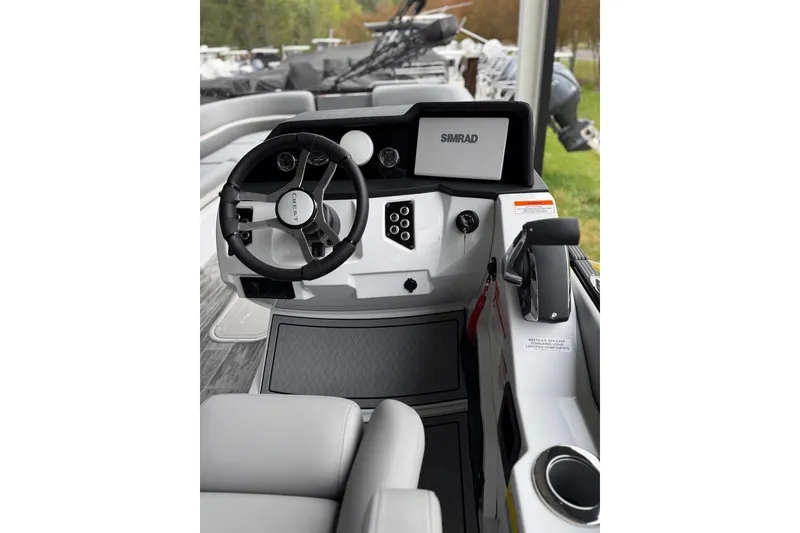 Slide: The Image of 2026 Crest Caribbean 250 SLRC boat helm with steering wheel and Simrad display. - 19